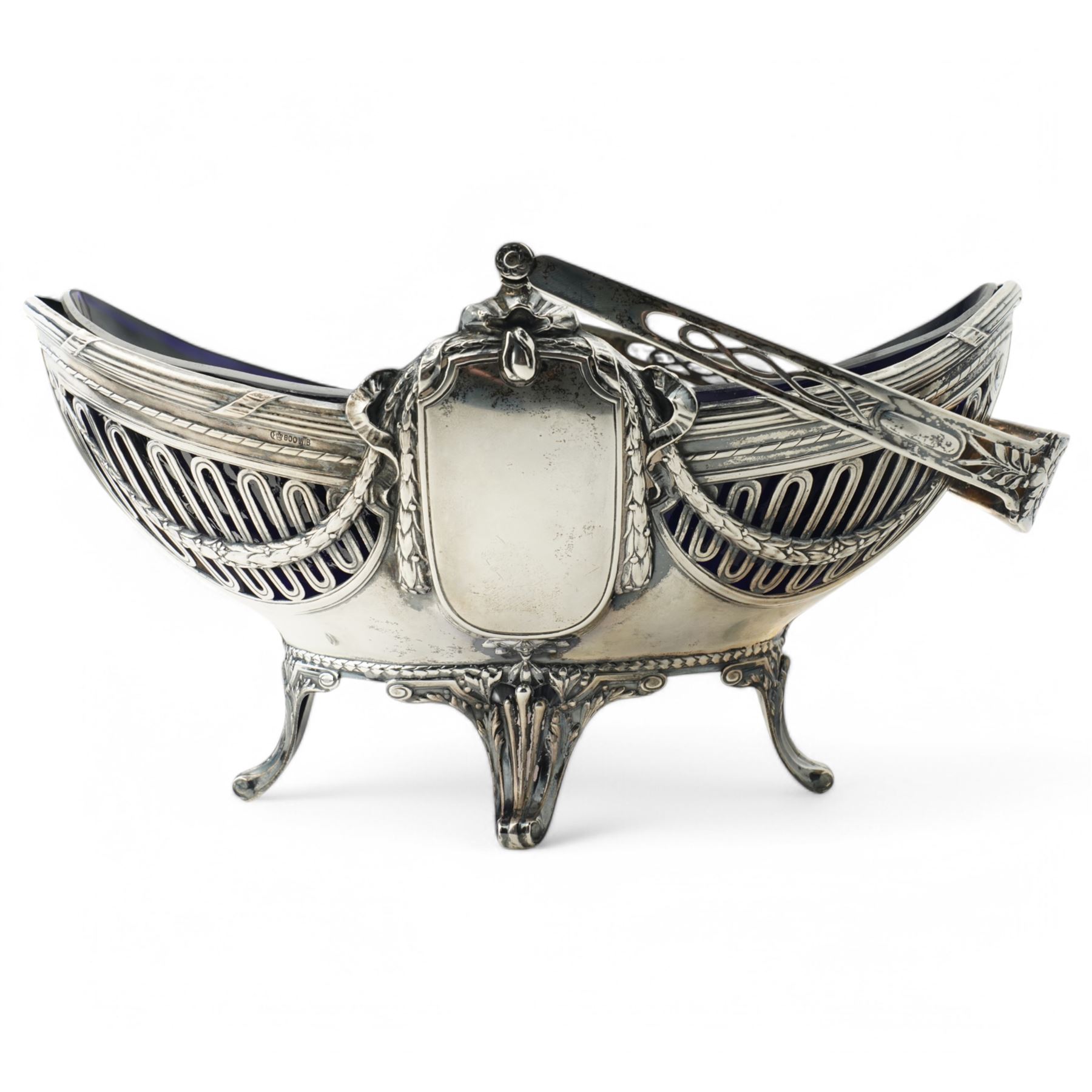 German standard 800 silver oval centrepiece with pierced sides, trailing harebells and swing handle, blue glass liner on splay feet L29cm Maker Wilhelm Binder