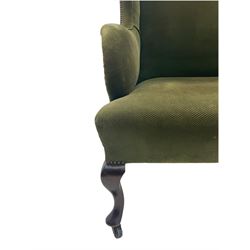 Early 20th century wingback armchair, wide seat, upholstered in green fabric with studded detail, cabriole front supports, on brass and ceramic castors 