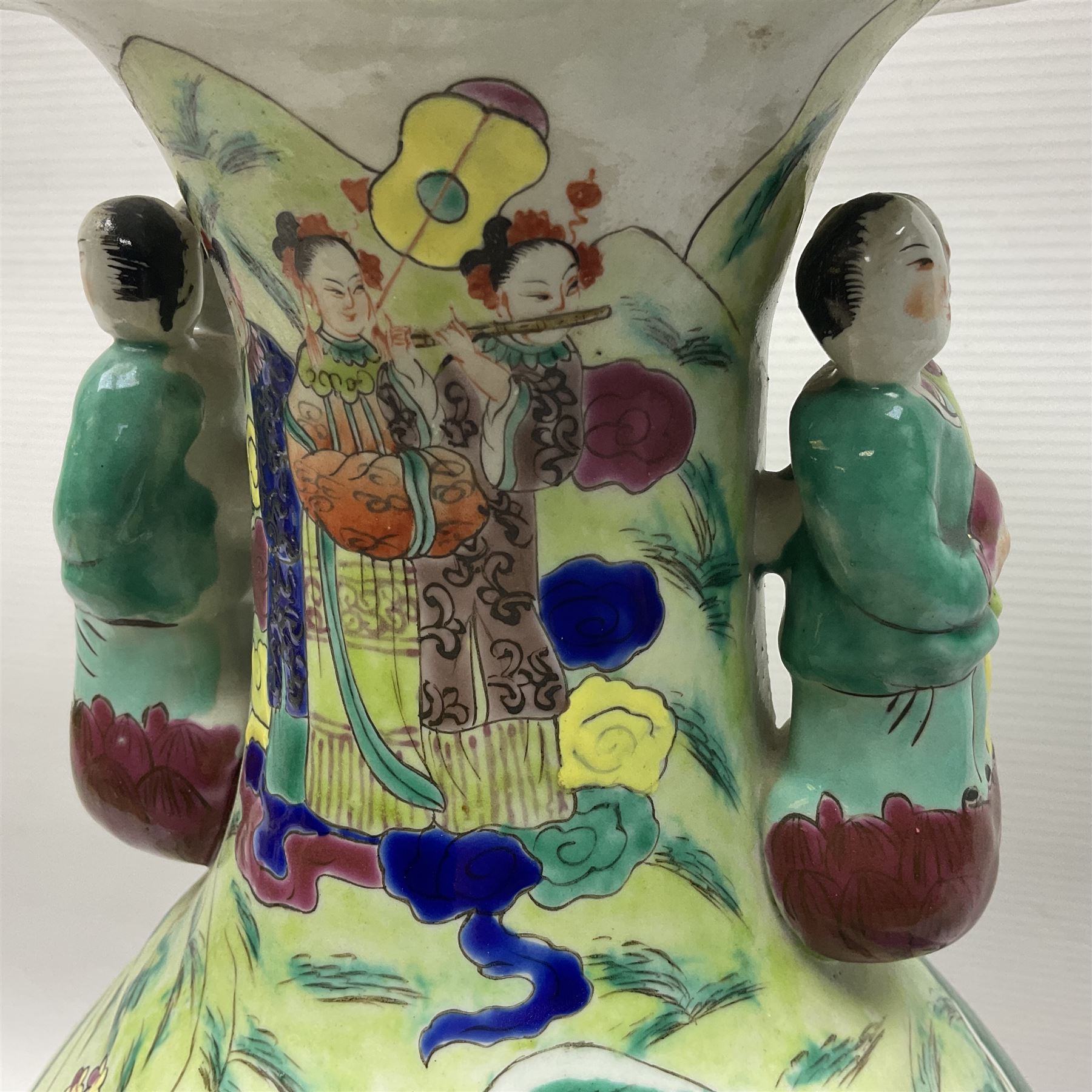 20th century Chinese Famille Rose vase, of baluster form with flared lobed rim and twin figural handles, decorated in polychrome enamel with figures dancing and playing instruments within a garden setting, H42cm