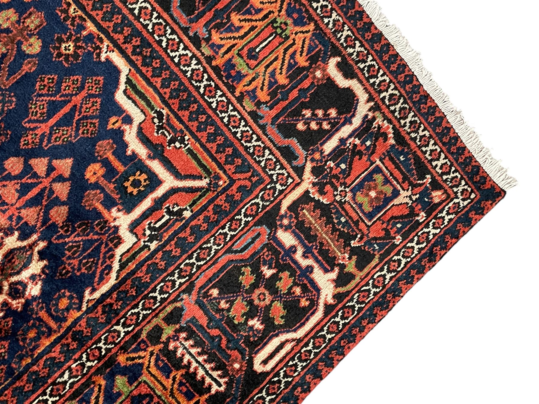 Persian Joshgan red ground rug, the medallion, field and spandrels decorated with clusters of Pitrak and tree of life motifs, the border with repeating design decorated with stylised plant motifs, within guard stripes