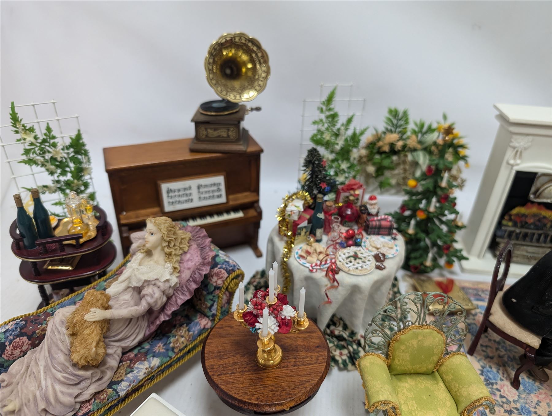 Dolls house furniture, including pianos, fireplace, plants, flower arrangements, tables, chairs, six figures and a collection of instruments and other accessories