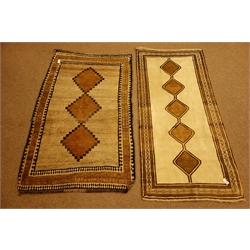  Two ceream ground Bakhtiari rugs, joined lozenge medallions with geometric borders, 215cm c 134cm max (2)  