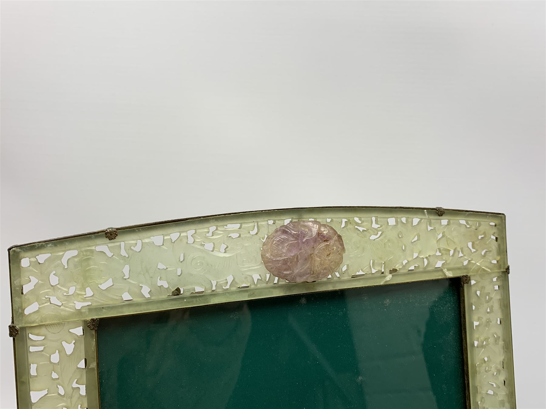 Early 20th century Chinese jade mounted photograph frame, of rectangular form the pierced jade frame carved with flowers and birds, the top panel carved with Foo dogs flaking an applied carved lavender coloured boss, with easel support verso, H33cm
