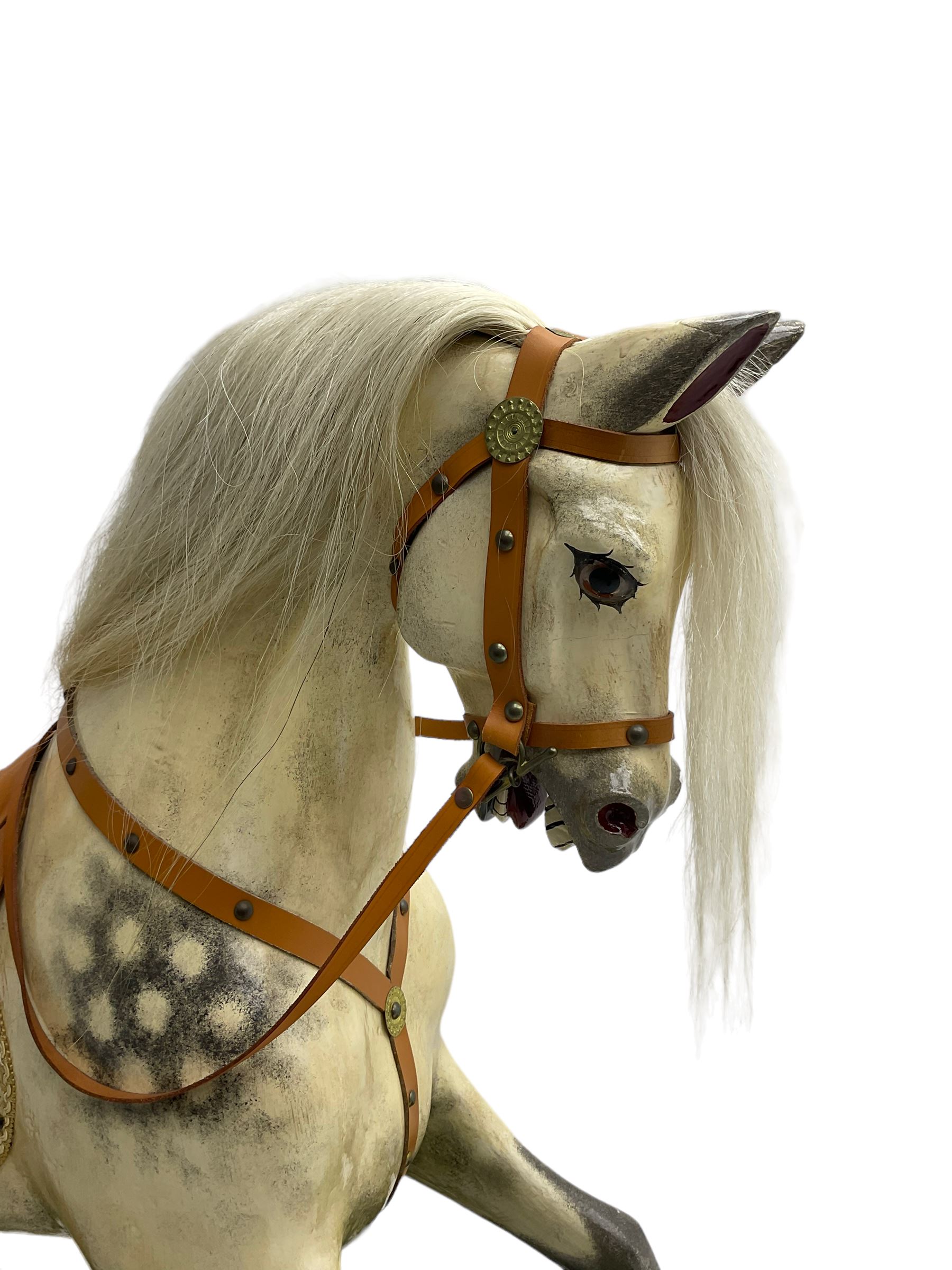 Attributed to F. H. Ayres - early 20th century carved wooden dapple grey rocking horse, with leather saddle and tack, with glass eyes, on green painted trestle base with turned column supports