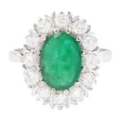 White gold emerald and diamond cluster ring, single oval cut emerald of approx 1.35 carat,...