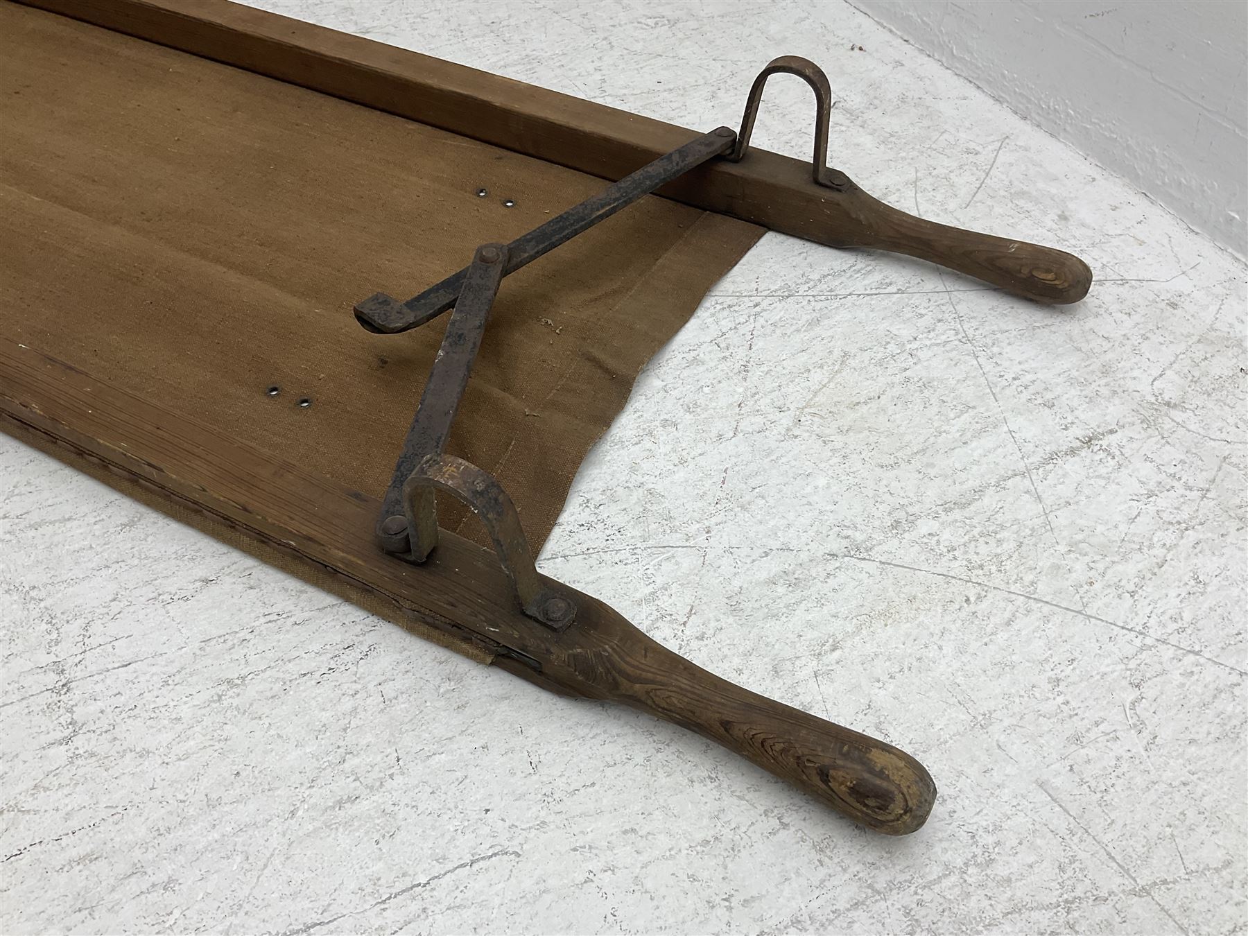 WW1 British casualty stretcher with iron mounted pitch pine sides and canvas base; stamped 'HL1917' and L7 with broad arrow in a triangle L236cm ( reputedly recovered from a barn at Bapaume on The Somme)