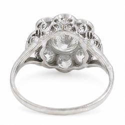 Early 20th century platinum diamond daisy flower head cluster ring, principal round cut diamond of approx 0.65 carat, surrounded by eight milgrain set old cut diamonds, within a pierced scroll design gallery, total diamond weight approx 2.15 carat