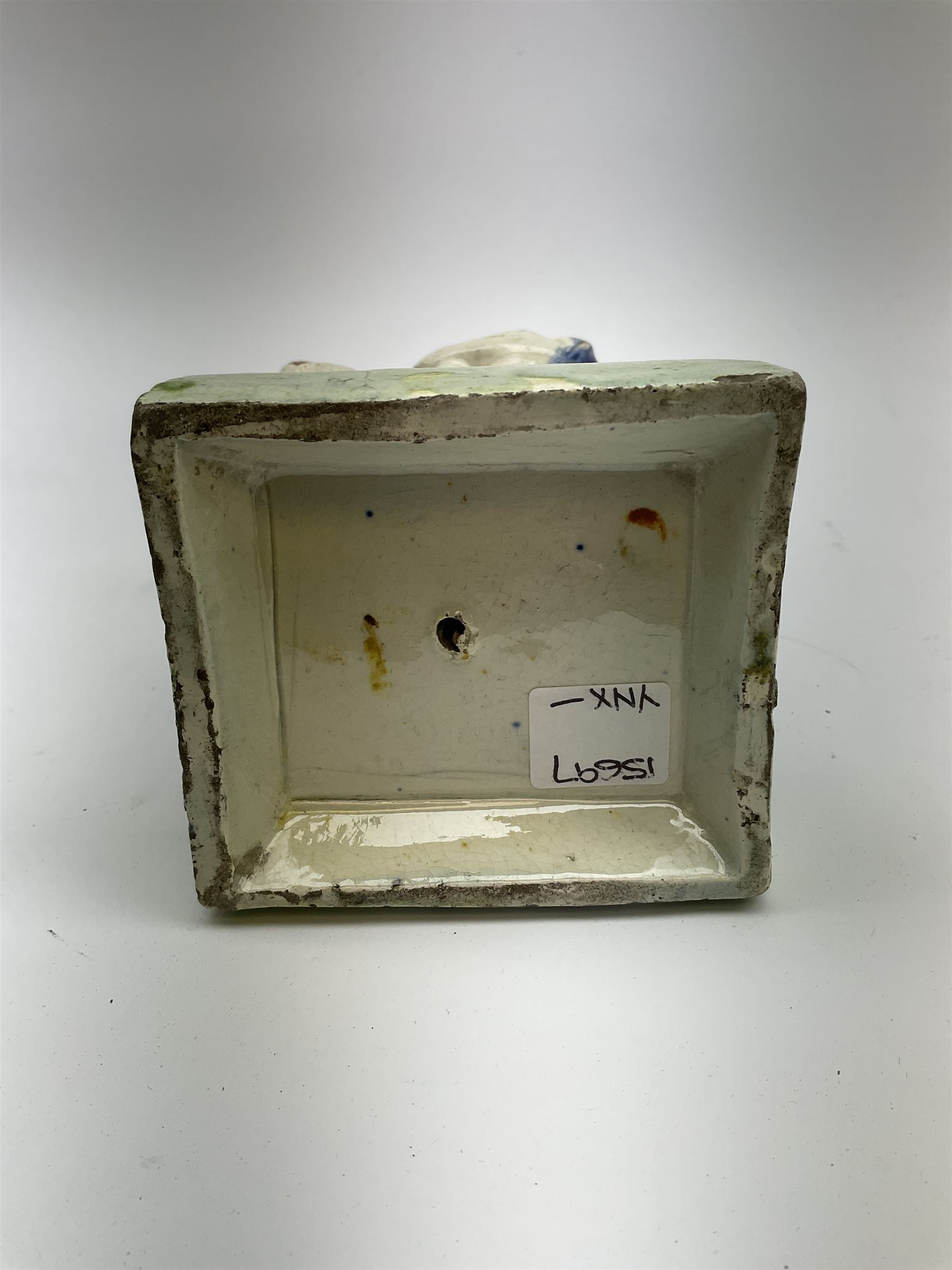 Late 18th century Prattware figure representing Charity, modelled as a mother with baby in her arms and two small children clutching at her robes, upon a square base, overall H21cm.