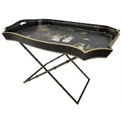 19th century design Chinoiserie style lacquered tray, painted with traditional scenes with figures and pagodas with gilt detail, on a folding simulated bamboo metal stand