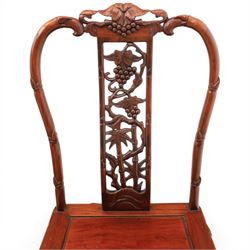 20th century Chinese ornately hardwood dining table and chairs, circular table with 'Lazy Susan' top with pierced carved frieze, raised on a quadriform base with carved foliate detail, the chairs en suite with carved pierced detailing  