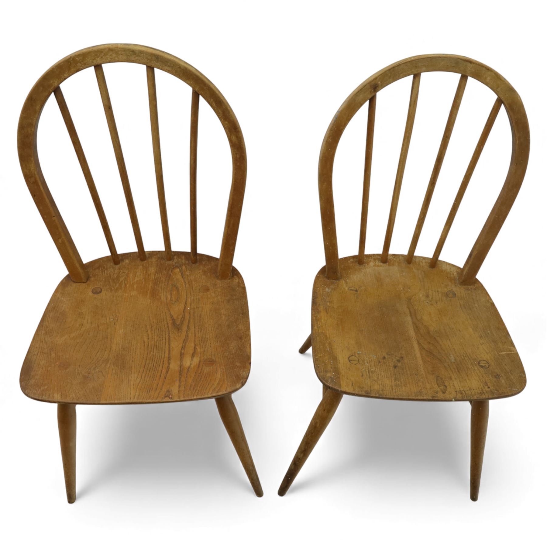 Ercol - Windsor dining chairs, set of four, each with rounded hoop back and four stick spindles, shaped elm seats with exposed plugs, raised on splayed beech tapering legs