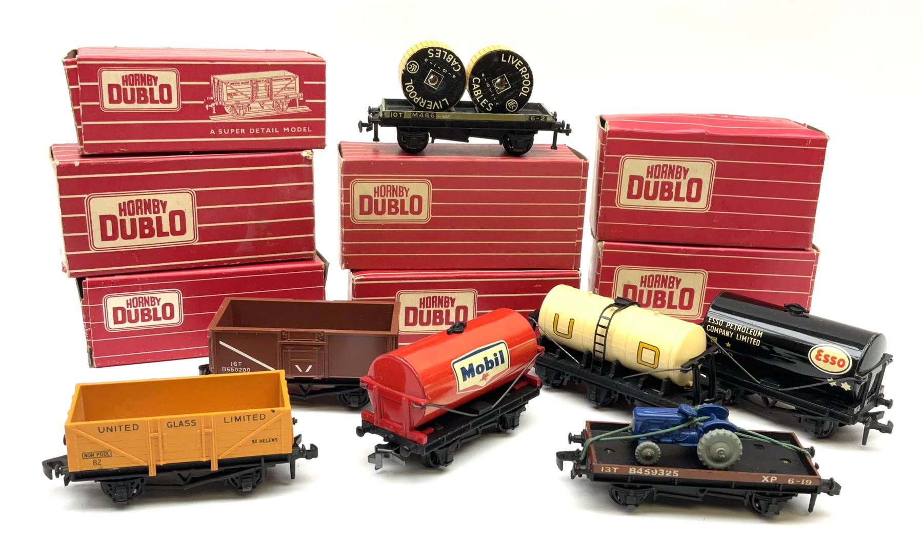 Hornby Dublo - 4646 Low-Sided Wagon D1 with cable drums; 4649 Low-Sided Wagon with tractor; 4656 16-Ton Mineral Wagon brown in Tony Cooper 1984 box; 4657 United Dairies Milk Tank Wagon; 4660 U.G.B. Sand Wagon; 4677 Tank Wagon 'Mobil' (D1); and 4680 Tank Wagon 'Esso' (Fuel Oil); all boxed (7)