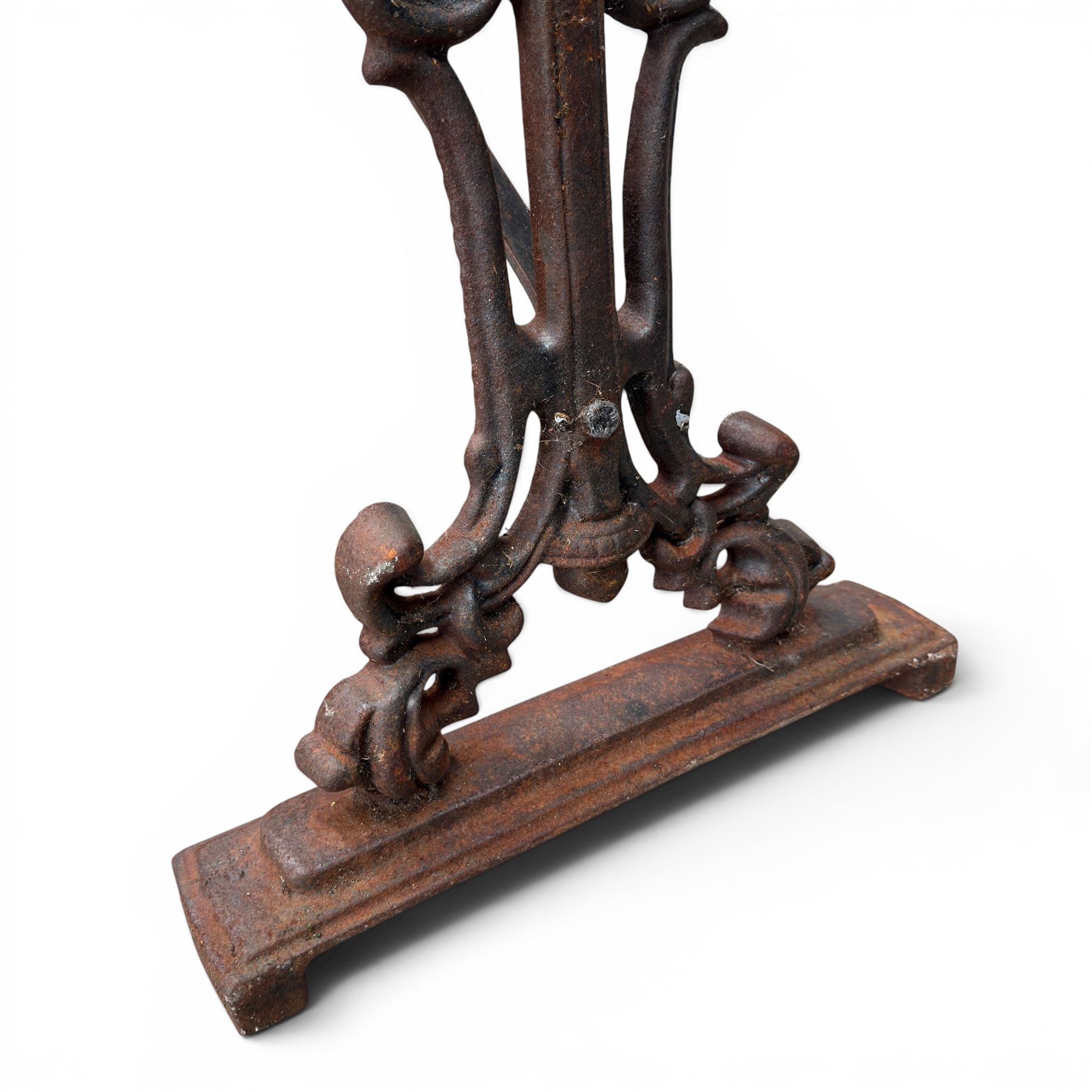 Pair of Victorian cast iron table end supports, of pierced and scrolling foliate design with central masks, united by X-form stretcher, with later top