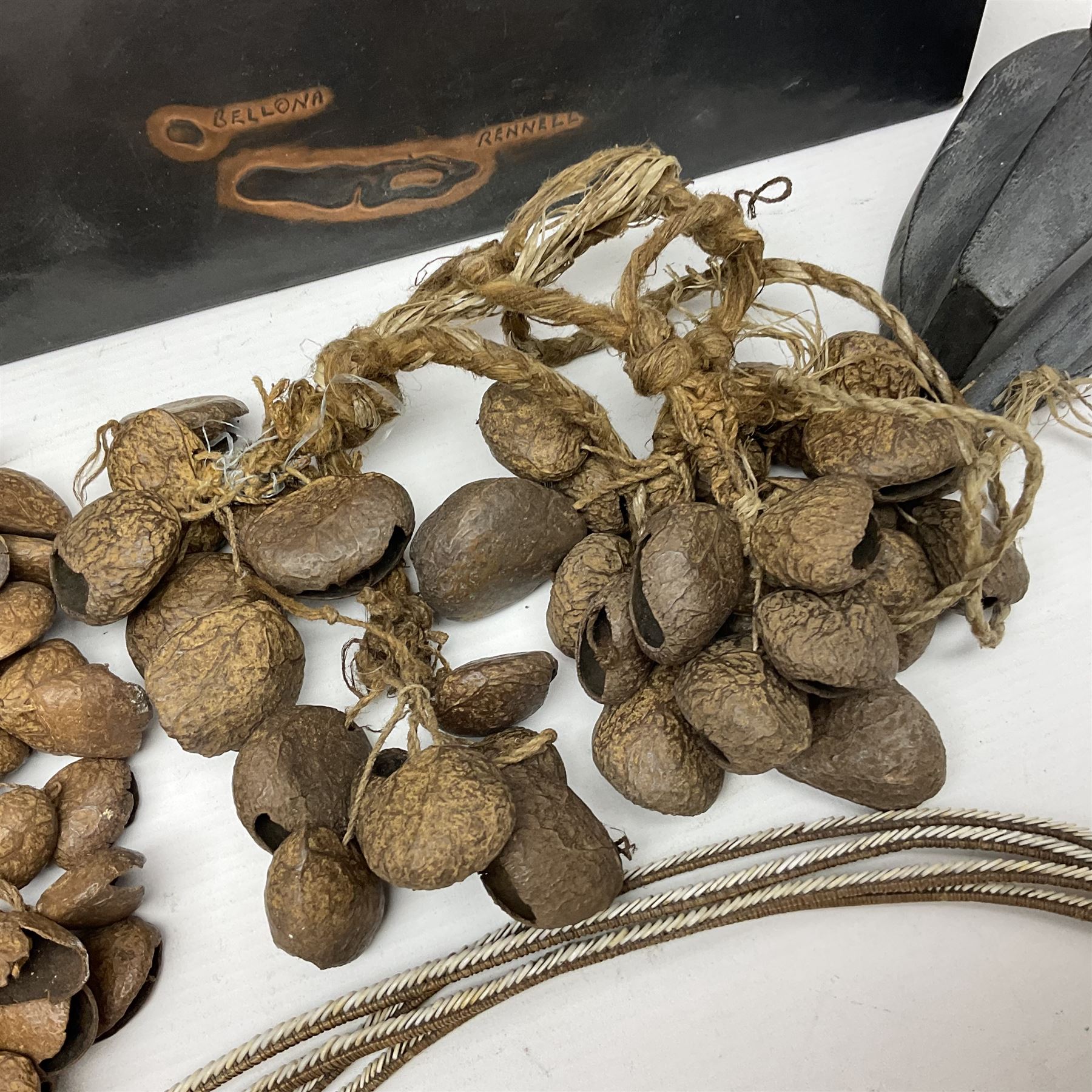 Collection of traditional necklaces from the Solomon Islands, including shell and boar tusk examples, together with a carved canoe prow, with mother of pearl eyes, painted cow hide and a copper plaque, depicting the Solomon Islands, with presentation engraving