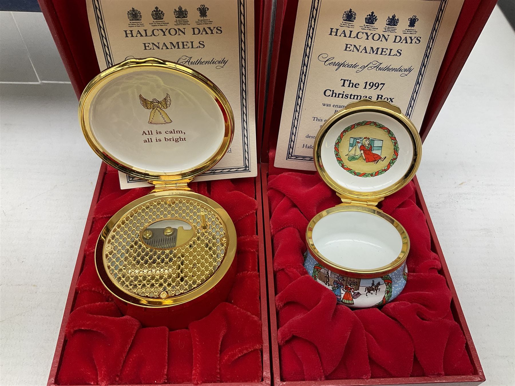 Eight Christmas themed Halcyon Days enamel boxes, and a Halcyon Days enamel bonbonniere modelled as a snowman, each in fitted box 