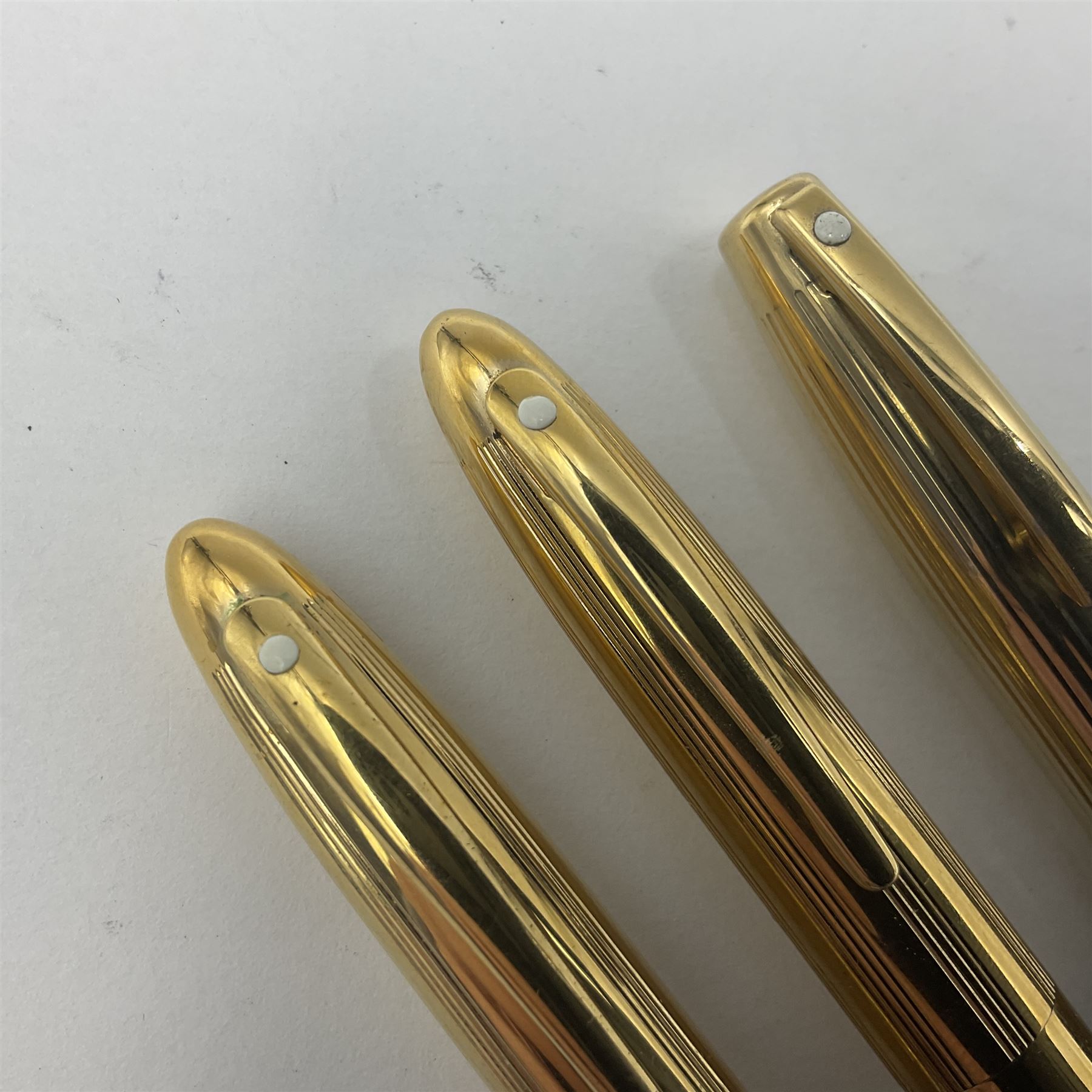 Sheaffer Crest fountain pen, the black barrel with gold plated cap and 18K nib, together with a matching ballpoint pen and further fountain pen, longest L14cm (3)