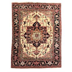 North West Persian Heriz carpet, ivory ground with large central medallion and floral spandrels, triple band border with scrolling design decorated with flower head and plant motifs 