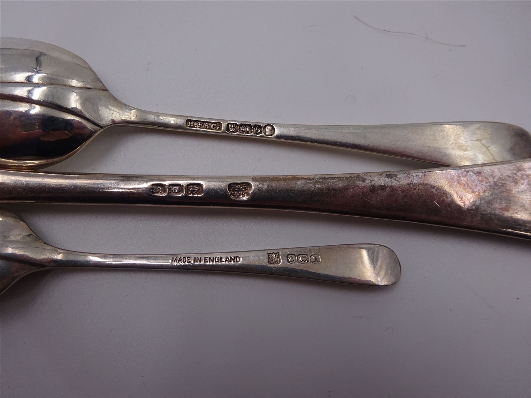 1930s matched set of silver Hanoverian pattern flatware, each with rattail bowls, to include four table spoons, twelve dessert spoons, twelve table forks, twelve dessert forks, twelve teaspoons and twelve coffee spoons, all hallmarked with various makers and dates 