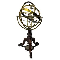 19th century brass terrestrial armillary sphere on rosewood base, lobe carved column on three splayed supports with scrolled carved terminals, the supports united by circular compass with turned stretchers