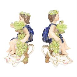 Pair of 19th century Stevenson and Hancock Derby figural chambersticks, each modelled as a seated cherub with arm around foliate encrusted sconce, marked beneath, H18cm