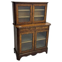 Late 19th century continental display cabinet, the upper section is glazed with twin doors with two upholster shelves, over a lower section with single draw above two glazed cupboard doors on shaped bracket feet