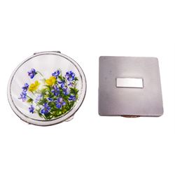 Mid 20th century silver and enamel compact, the cover decorated with purple and yellow flowers, lifting to reveal a mirrored interior and powder compact, hallmarked Henry Clifford Davis, Birmingham 1952, D9cm, together with a mid 20th century silver compact, of square form, with engine turned decoration and vacant central panel to cover, lifting to reveal mirrored interior with powder compact, hallmarked W H Manton Ltd, Birmingham 1946, W7.2cm