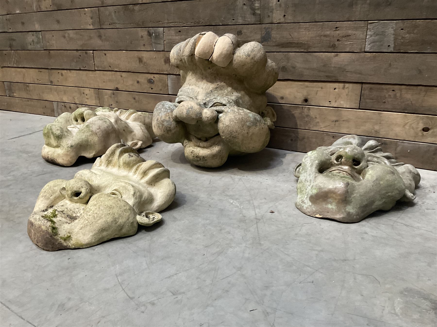 Four grotesque garden wall masks