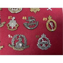 Twenty-two glengarry and cap badges including Argyll & Sutherland, Devonshire, Essex, Hampshire, Royal Berkshire, Northamptonshire, Long Range Desert Group, Royal Corps of Signals, Norfolk, Dorsetshire, East Lancashire etc; mounted on a board for display