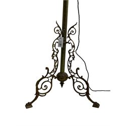 Victorian brass floor standing oil lamp, column decorated with ivy and acanthus leaves, the tripod base pierced with scrolled foliate decoration, with ivory and gilt shade, later converted to electricity