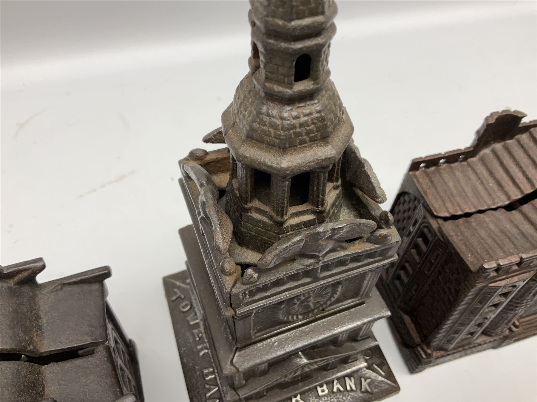 Five early 20th century cast-iron money banks as buildings - 'City Bank' c1904 H10cm; 'County Bank' c1905 H11cm; 'Town Hall Bank' c1900 H8.5cm; 'Tower Bank' c1902 H23.5cm; all made by John Harper; and 'Blackpool Tower Bank' c1907 by Chamberlain & Hill H18.5cm (5)