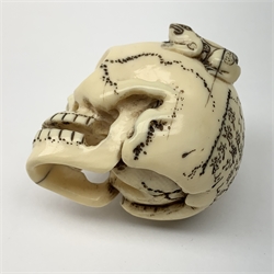Japanese Meiji carved ivory netsuke, modelled as a skull, the top carved with two toads, and script and signature to reverse, L5cm, H4cm   