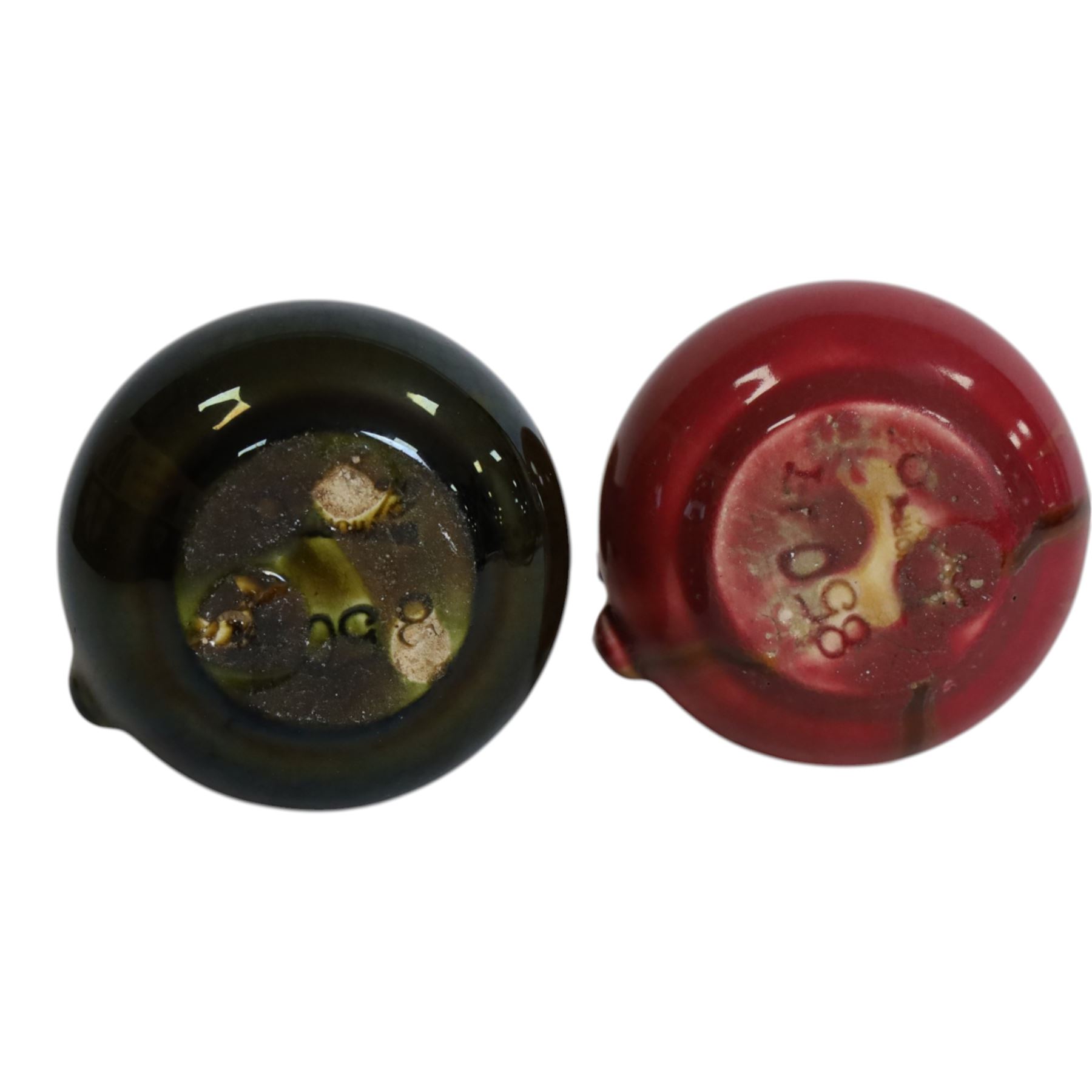 Christopher Dresser for Linthorpe Pottery, two of miniature jugs in red and green, shape number 850, with impressed mark beneath, H9cm