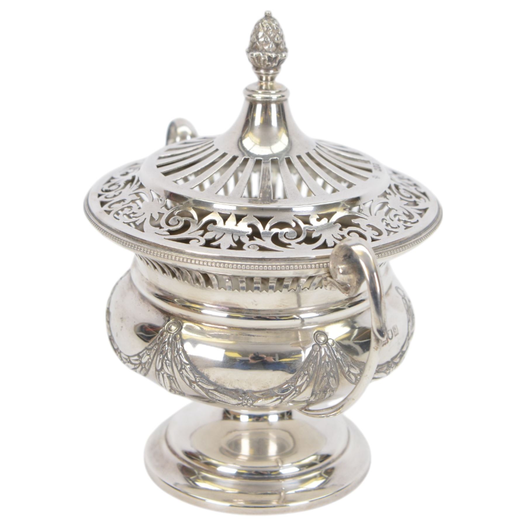 Early 20th century silver twin handled lidded bowl, of circular form with C scroll handles, the body embossed with floral swags, the pierced lid with pineapple finial, hallmarked Horace Woodward & Co Ltd, London 1911, H16cm