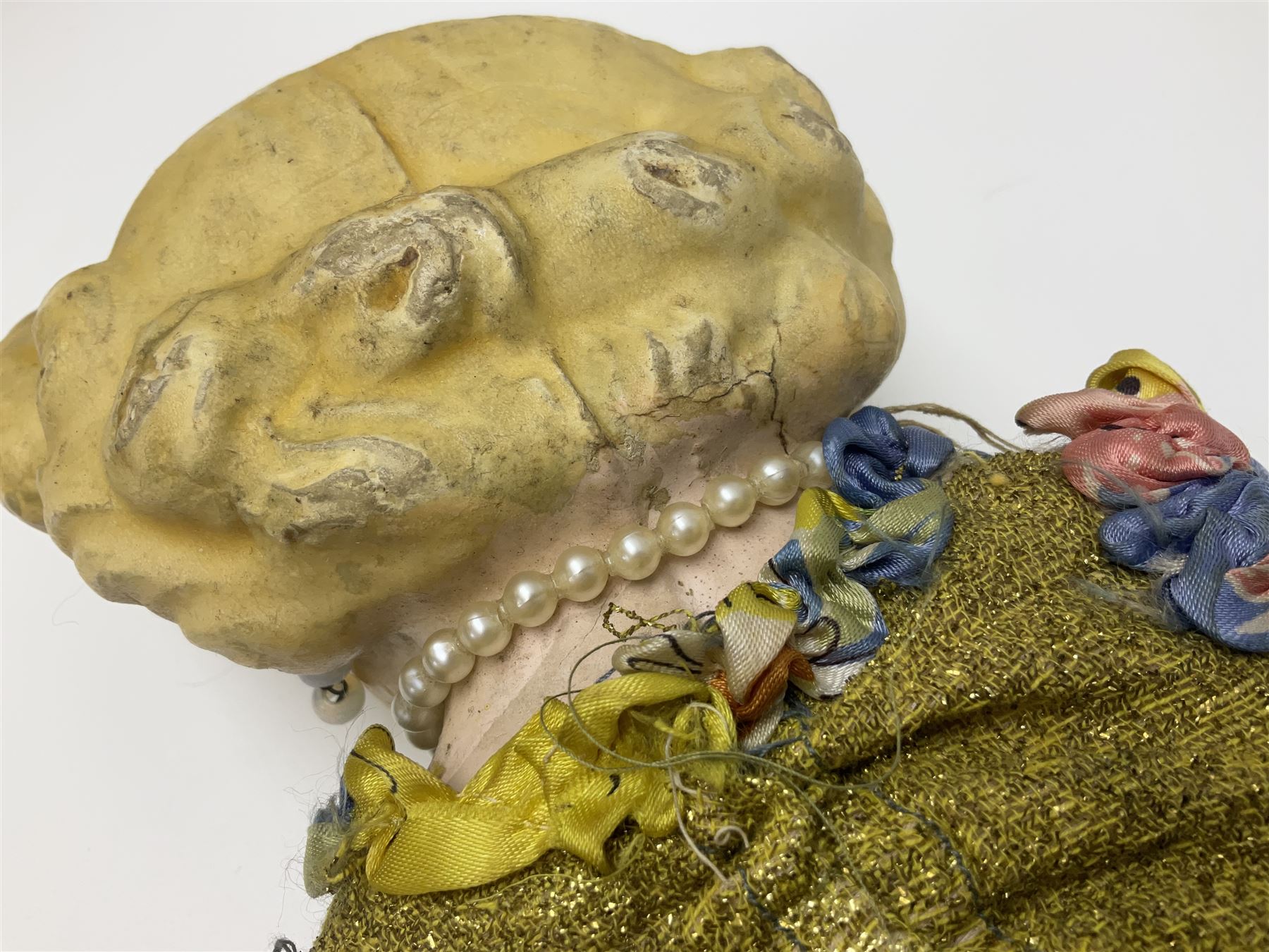 Victorian large wax over composition Pumpkin head doll, with inset dark glass eyes, moulded blonde hair in curls, stuffed body with carved and painted wooden limbs, grey painted boots, floral satin dress with netting underclothes H61cm