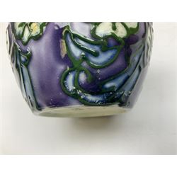 Three Minton Secessionist vases, with tube-lined stylised flower decoration, two upon a red ground and third upon a purple ground, all with printed mark to base 'Minton Ltd, No. 33', H13cm