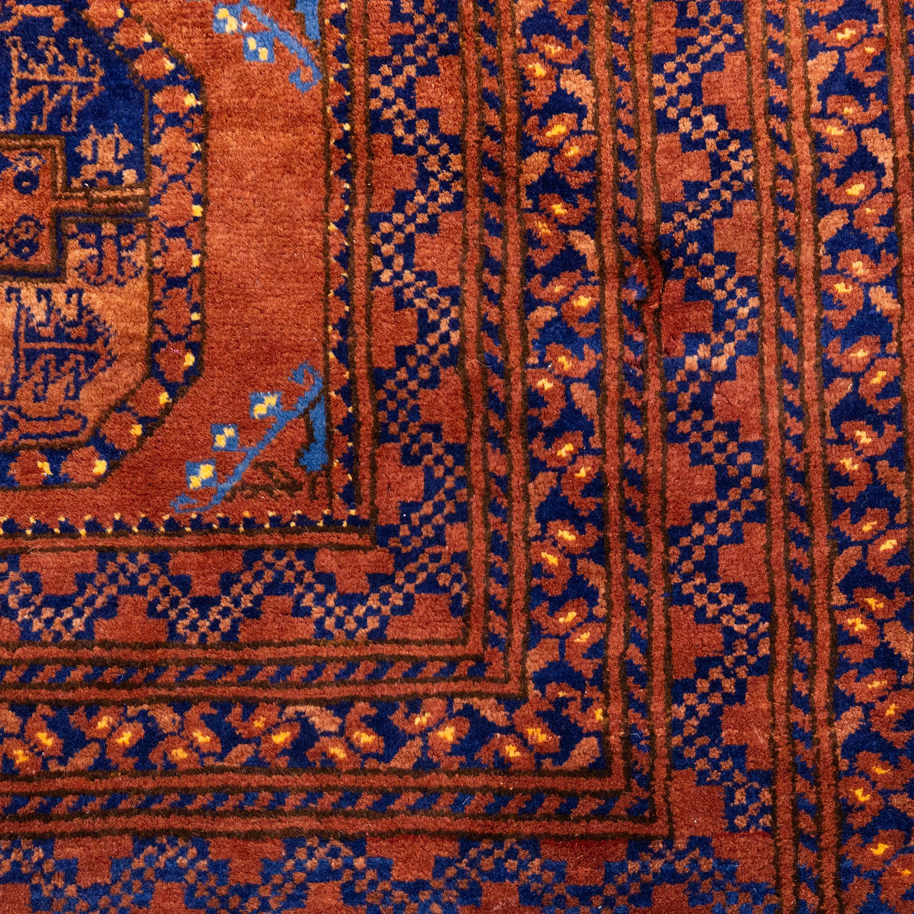 Pakistani Bokhara hand-knotted carpet, camel field decorated with rows of large tekke style octagonal guls enclosing stylized geometric motifs, interspersed with small stepped diamond devices within multiple geometric borders, with fringe ends 