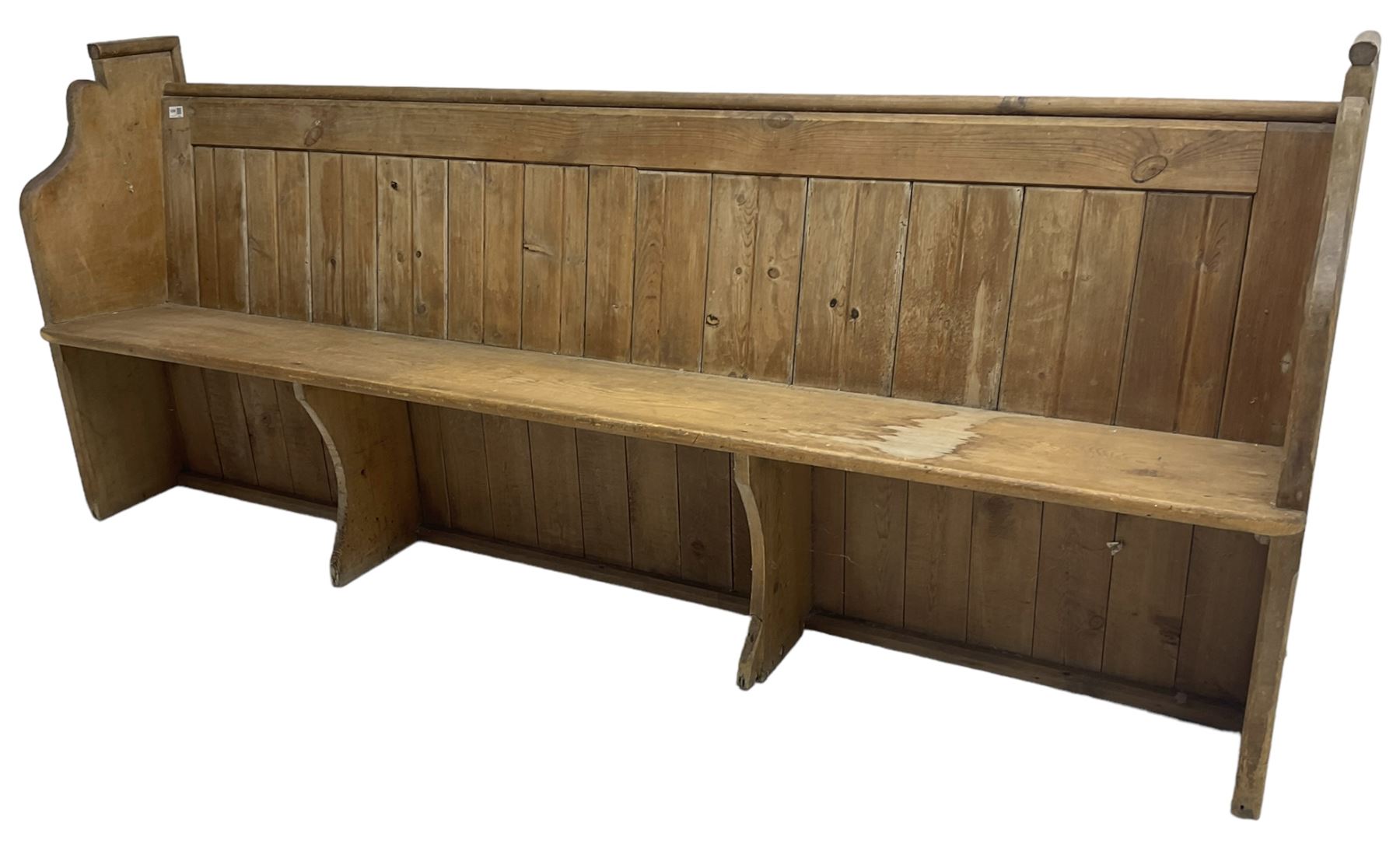 Early 20th century pine church pew, vertical plank back over rectangular seat, flanked by shaped end supports, with bible rest to back