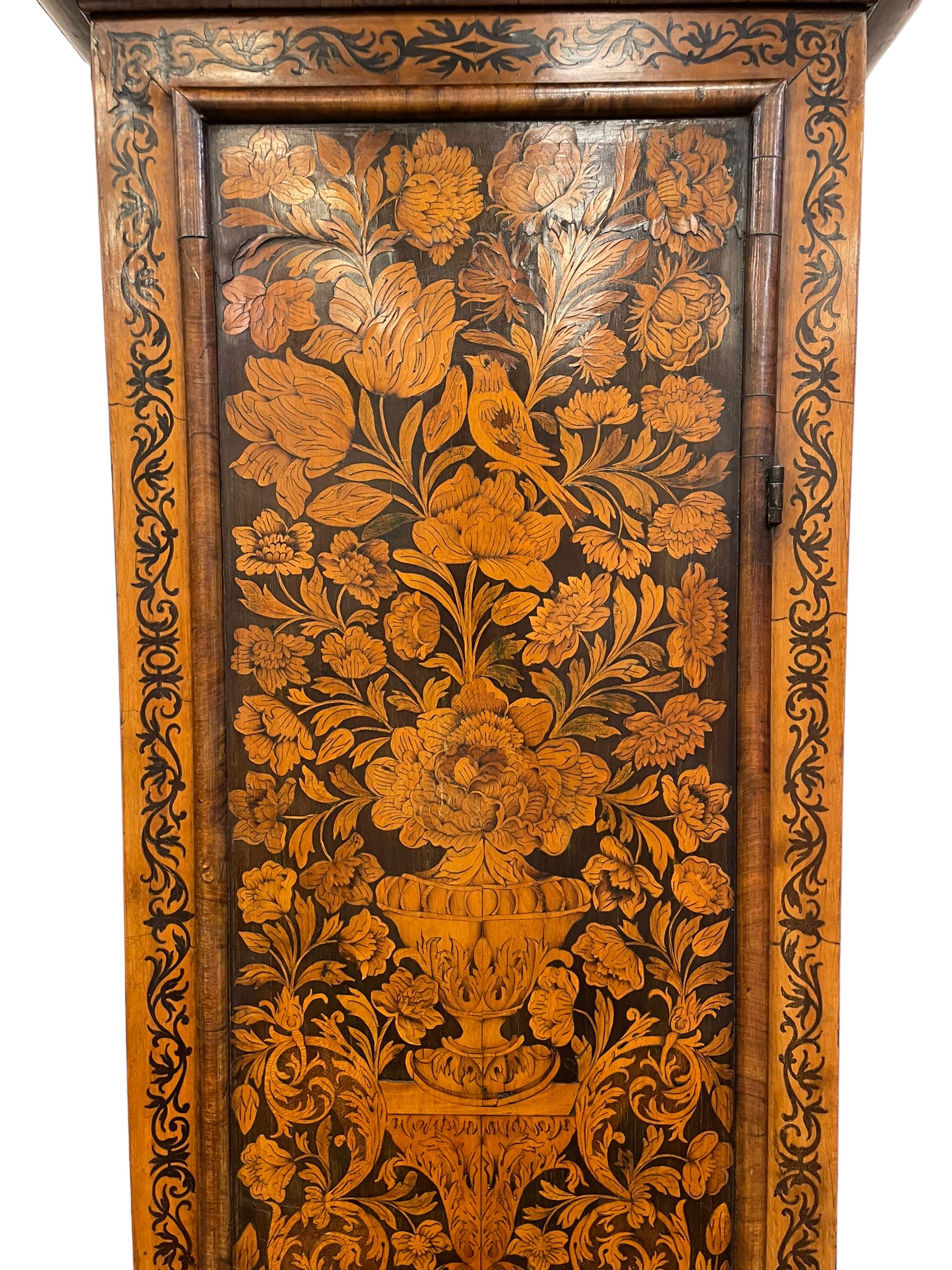 William & Mary floral marquetry 8-day longcase clock c 1700, later mid-18th century four pillar rack striking movement with a square brass dial and subsidiary seconds dial, ringed winding holes and calendar aperture to the matted dial centre, with London cherub head cast spandrels and (later) fretted steel hands, silvered Roman numeral chapter ring with stylised fleur di Lis half hour makers, narrow Arabic five-minutes, minute track and inner quarter hour track, signed Thomas Horlock, Hammersmith, 
case with box upstand to the domed floral marquetry decorated caddy with three brass flame finials, above a moulded cornice and fretwork frieze,  inlaid hood door with attached barley twist pillars to the front above an inlaid convex moulding, full length D moulded trunk door with a circular lenticle inlaid with floral and foliage panels inhabited with birds, on a conforming marquetry plinth with applied double skirting. Thomas Horlock is recorded as a Whitesmith & Clockmaker of Hammersmith, Middlesex.
A copy of Thomas Horlock's will dated the 15th June 1757 is held at The National  Archives Kew.