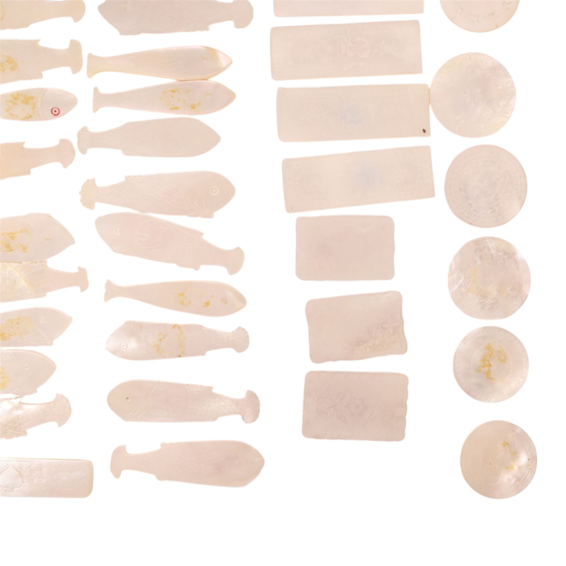 Collection of approximately sixty mother-of-pearl gaming tokens, including fish-shaped, rectangular, circular examples 