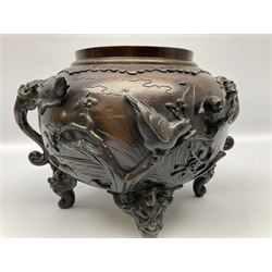 Japanese bronzed koro, the body of globular form with twin cast zoomorphic mask handles, decorated in relief with birds upon blossoming branches, against a ground incised with rushes and peonies, the flat toped domed cover with pierced band and surmounted by a cast figure of a Foo dog, the whole upon three zoomorphic mask feet, with impressed character type mark beneath, H35.5cm