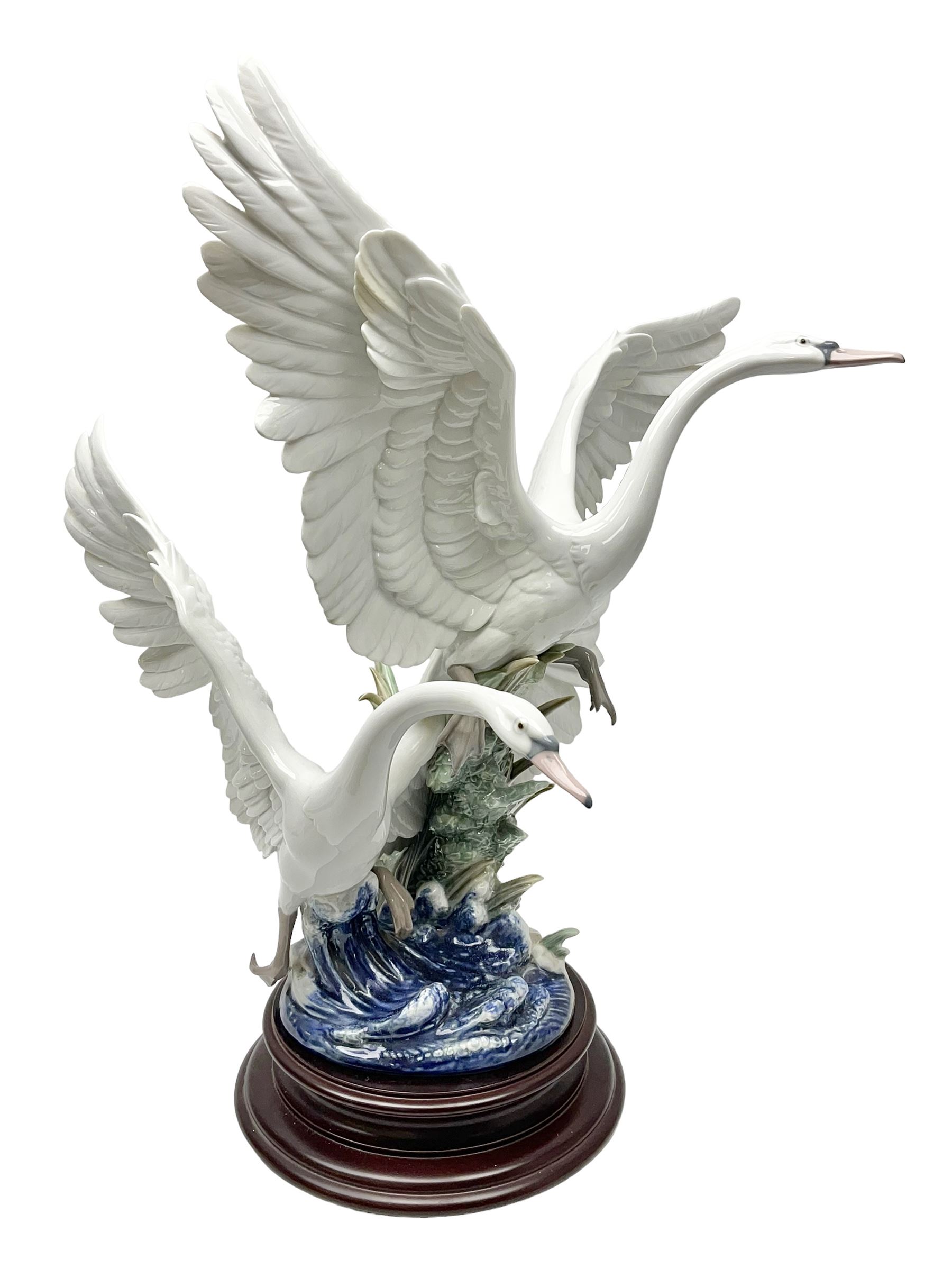 Large Lladro figure group, Swans Take Flight, modelled as two swans upon raised on circular wooden plinth, sculpted by Salvador Debon, H68cm