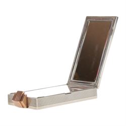 Mid 20th century French silver and gold vanity case, of rectangular form, the hinged cover decorated with an openwork panel of bids and cabochon ruby studded flower heads, opening via a pull clasp to reveal a mirror to the underside and compartment with lift up cover, signed J. Lacloche Paris Cannes, and bearing French assay marks, not including clasp L10cm W6cm D1.5cm

