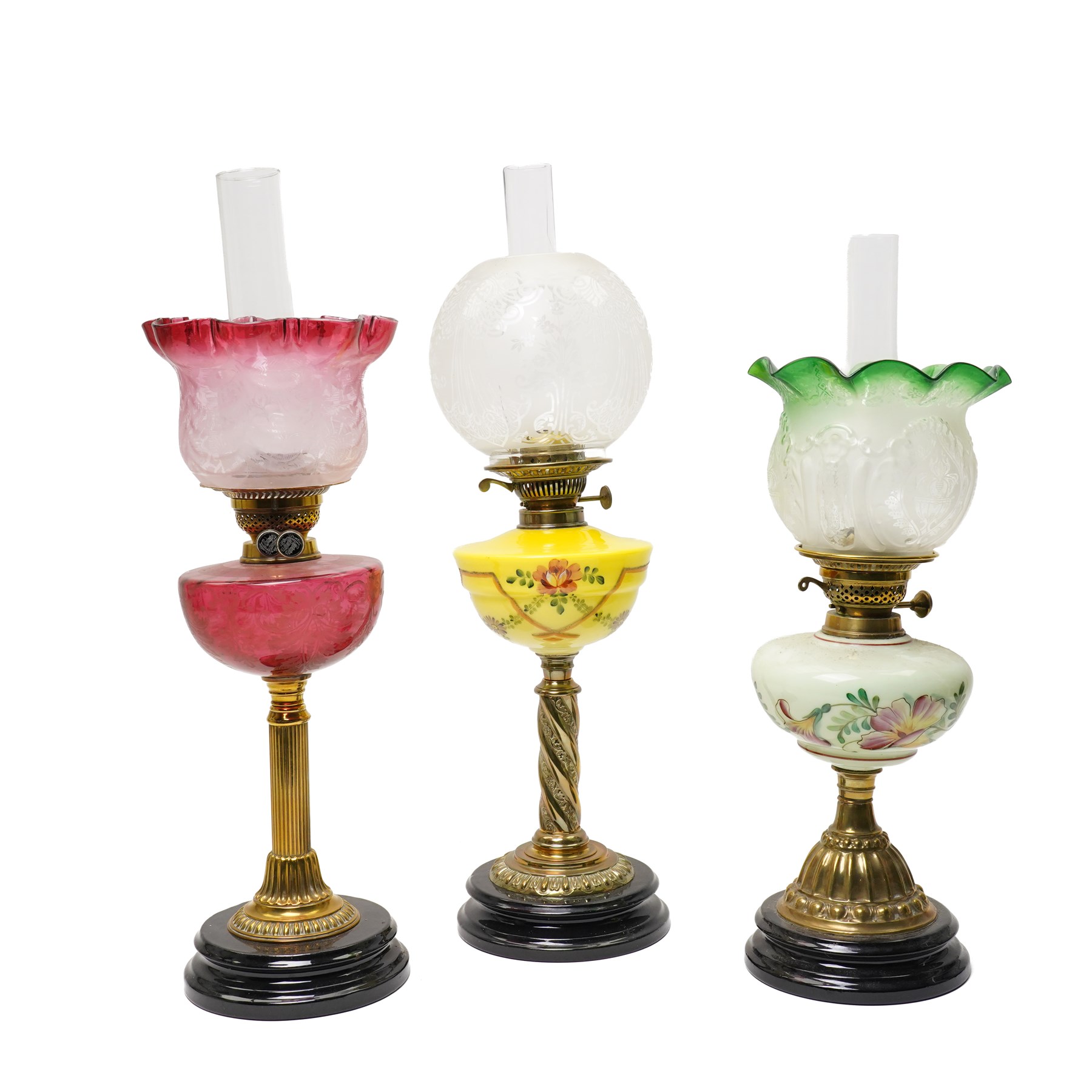 Victorian table oil lamp with floral painted yellow glass reservoir on brass column, another with cranberry glass reservoir and shade and another with painted green glass reservoir (3)