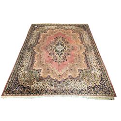 Large Persian design peach ground carpet, the field decorated with floral medallion, multi-band border decorated with repeating flower head pattern