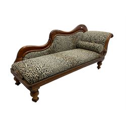 Victorian mahogany framed chaise longue, shaped arm carved with acanthus leaves, the scrolled back with applied carved rosettes,upholstered in monochrome leopard print fabric with bolster cushion, raised on turned supports