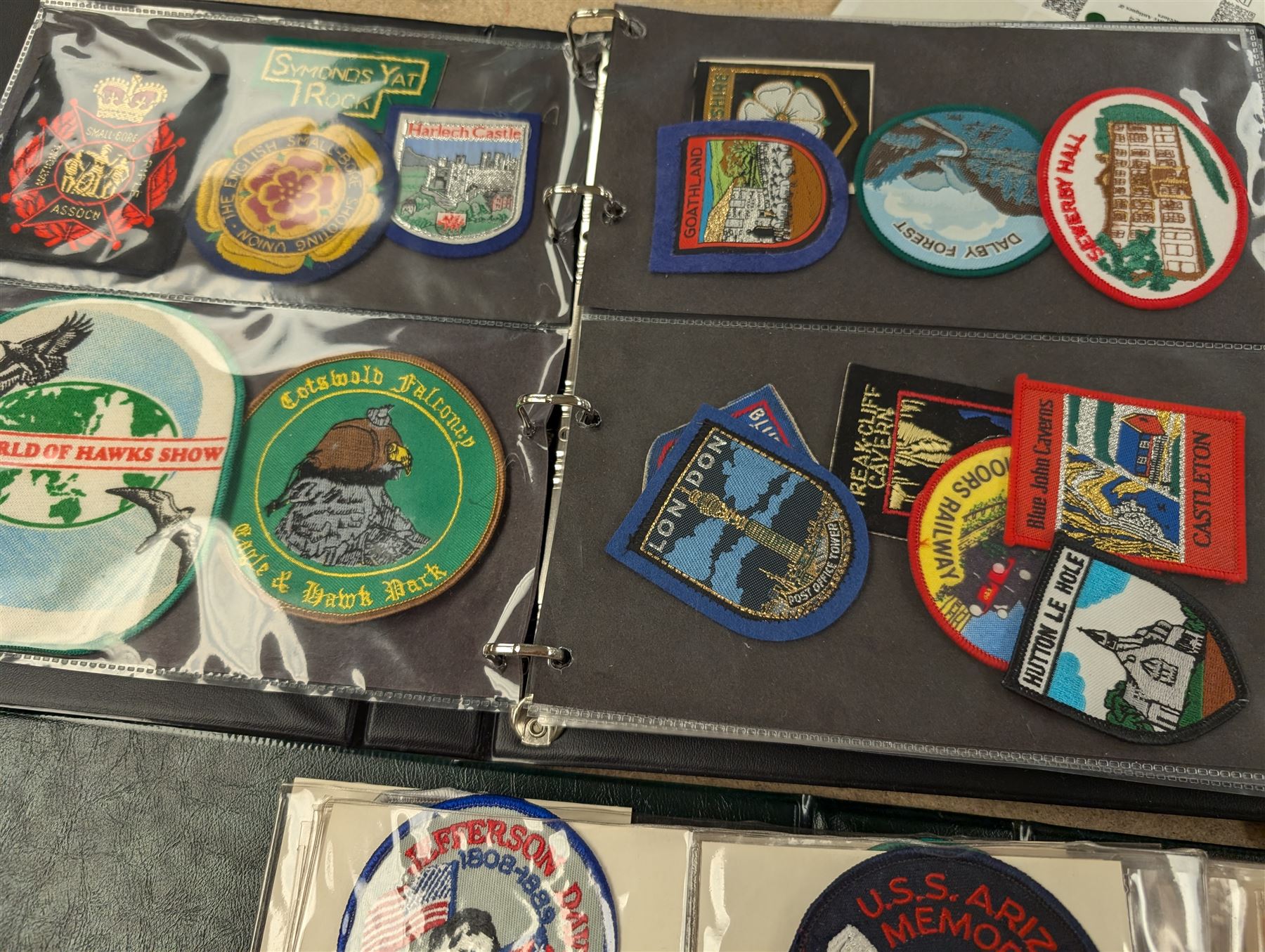 Large collection of souvenir cloth badges and vinyl stickers, mostly contained within albums