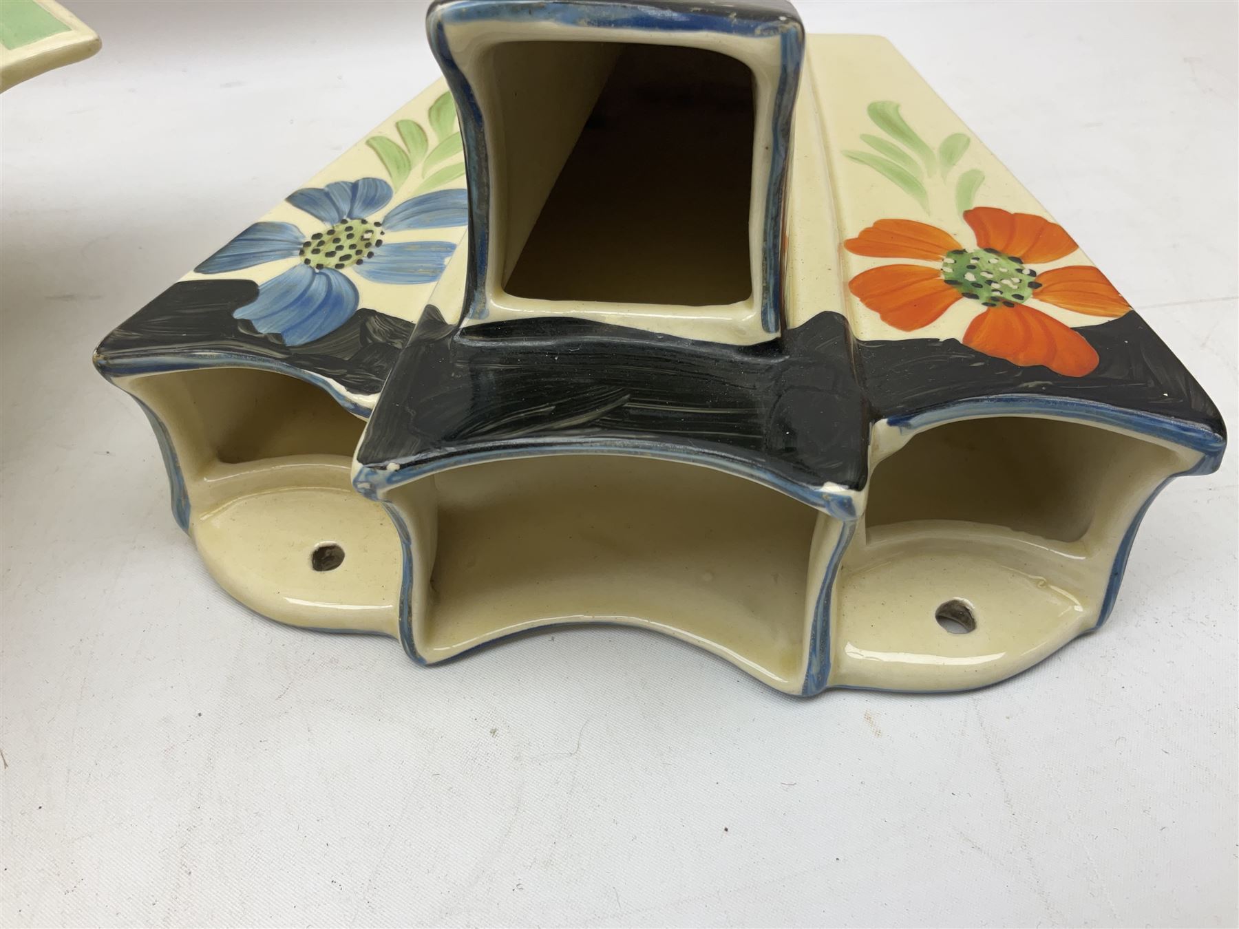 Group of Art Deco ceramics, comprising Wadeheath jug painted in spiralled bands of blue, orange, yellow and brown, shape no. 707784, Royal Doulton Caprice pattern twin handled bowl, no. D5358, Arthur Wood wall pocket of typical stylised fan form with painted floral decoration, Arthur Wood vase of cornucopia form with red and grey floral decoration, Wadeheath jug of ribbed form with stylised handle, and two Hancock's Ivory Ware jugs, tallest example H26cm