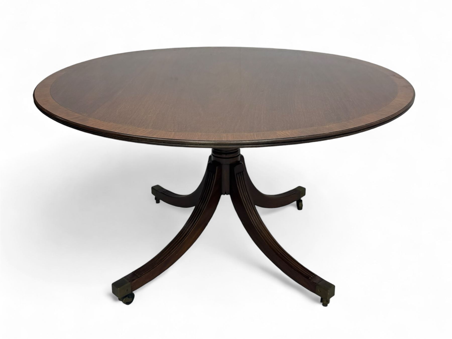 Early 20th century Regency design mahogany tilt-top table, circular top with edge banding, supported by a central turned pedestal with four reeded sabre supports terminating in castors; six chairs with pink upholstered drop in seats (7)