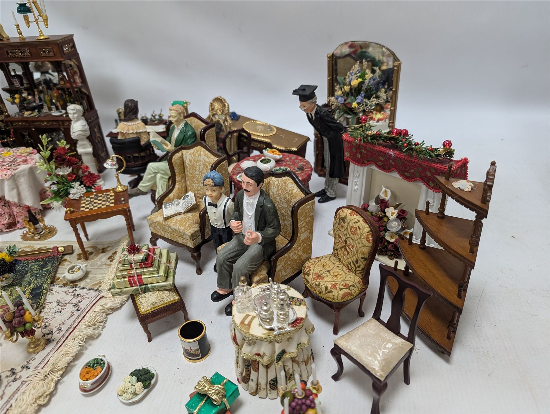 Dolls house living room and dining room furniture, including arm chairs, desk, fireplaces, dressers, tables, eight figures and a large collection of predominantly Christmas themed food, accessories and decorations