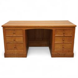 Mouseman - oak pedestal kneehole desk, adzed rectangular top over twin pedestals each fitted with three drawers, arched kneehole with panelled interior, on plinth base, signature carved mouse to side, by the workshop of Robert Thompson, Kilburn